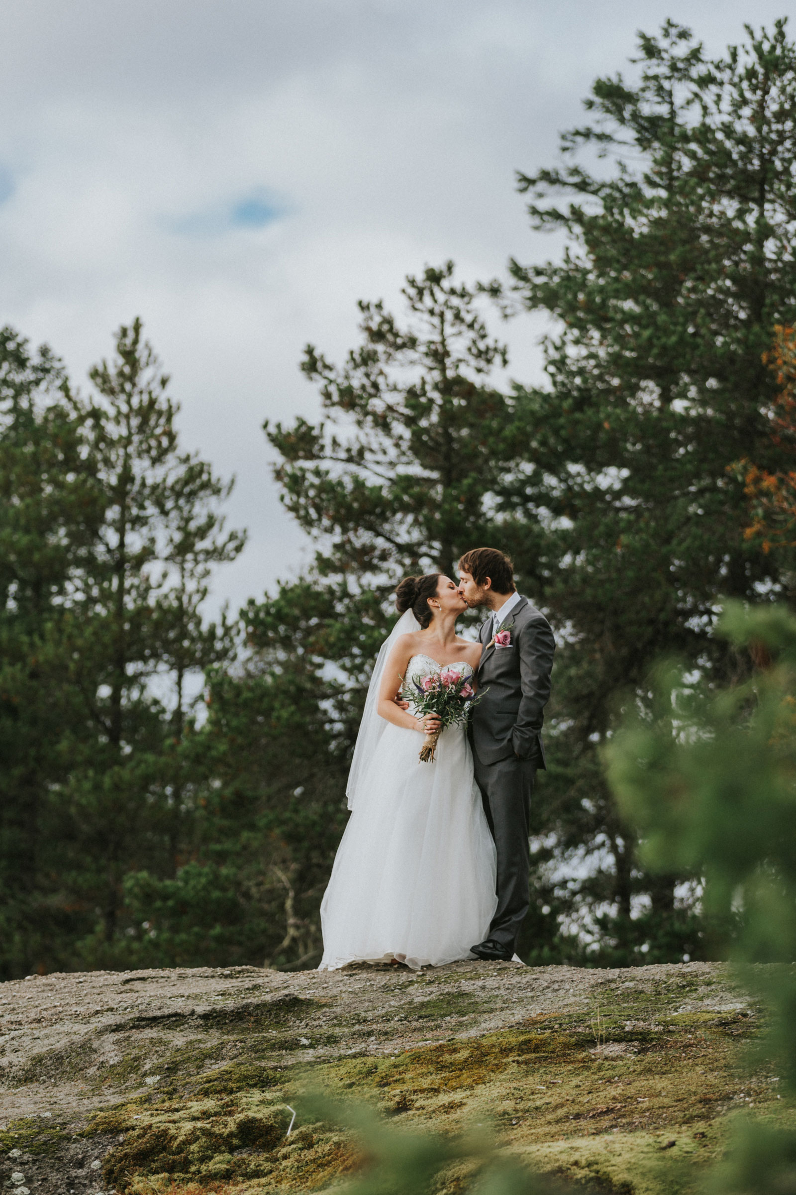 Bride and groom kissing in the trees at Little Mountain