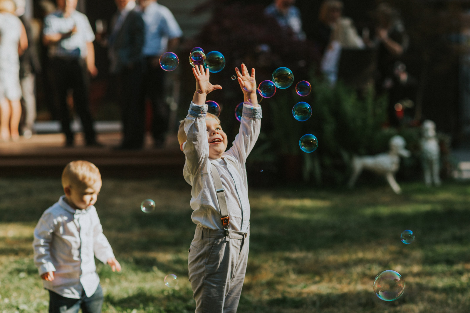 Kid wearing suspenders playing with bubbles