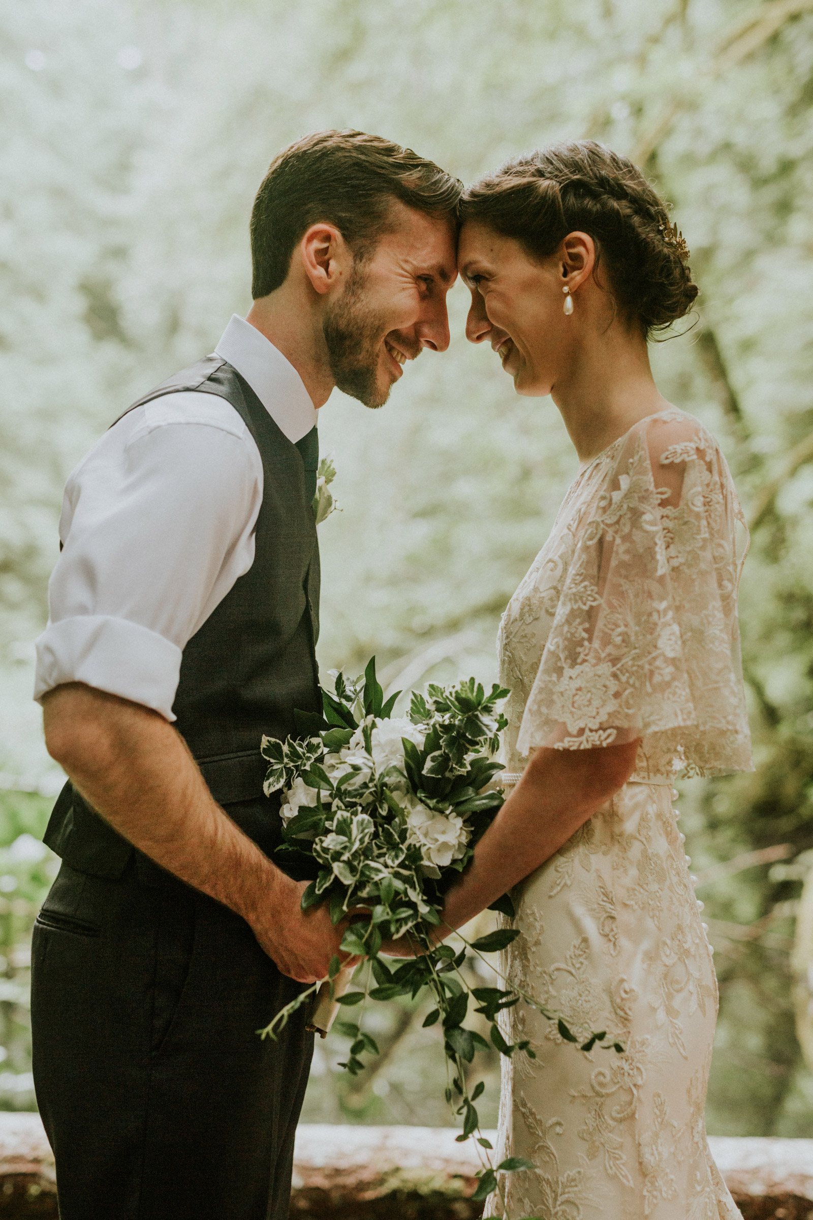 Bride and groom standing and touching foreheads